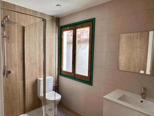 a bathroom with a toilet and a sink and a window at CozyCatalonia - Exclusive Attic in Central Blanes in Blanes
