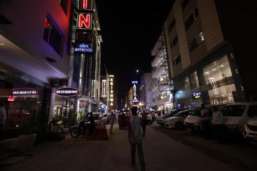 a man walking down a city street at night at Hotel Godwin Deluxe - Free Airport Pick-Up in New Delhi