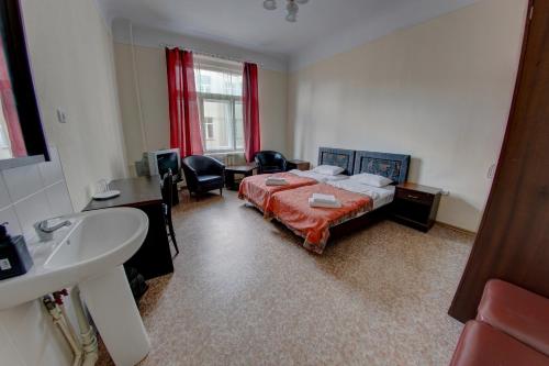 a bedroom with a bed and a sink and a bathroom at Hostel Viktorija with Private Rooms in Riga