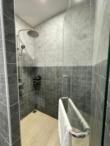 La salle de bains est pourvue d'une douche avec du carrelage gris. dans l'établissement Kata Noi Place, à Kata Beach