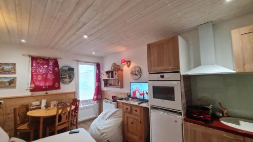 une cuisine avec une table, un évier et un comptoir dans l'établissement Cocoon des sommets enneigés, à La Foux