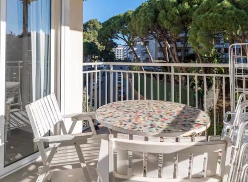 einen Tisch und zwei Stühle auf einem Balkon mit einem Tisch in der Unterkunft Apartamentos Playa Caballo Blanco in Salou