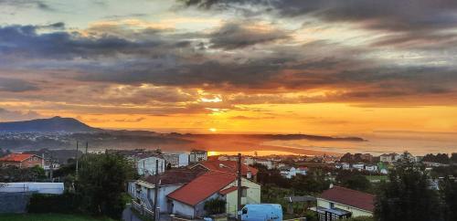 a view of a city with the sunset in the background at Casa Andrea in Valdoviño