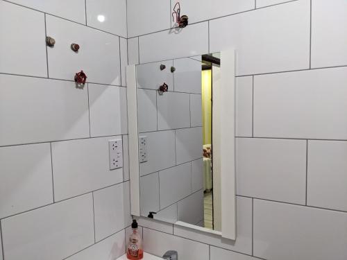 ein Bad mit weiß gefliesten Wänden und einem Spiegel in der Unterkunft Killi View Villa in Moshi