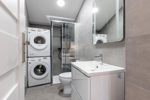 a bathroom with a washing machine and a washer and dryer at Maisonnette à 400m de la Plage in Villeneuve-Loubet