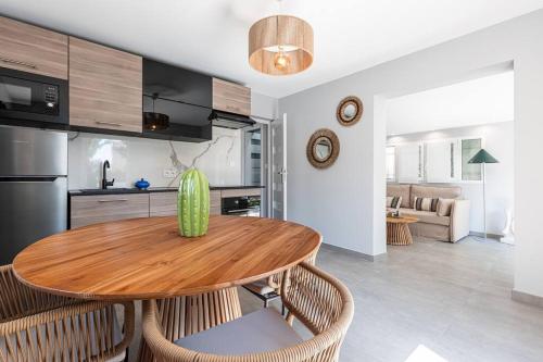 une cuisine et une salle à manger avec une table et des chaises en bois dans l'établissement Maisonnette à 400m de la Plage, à Villeneuve-Loubet