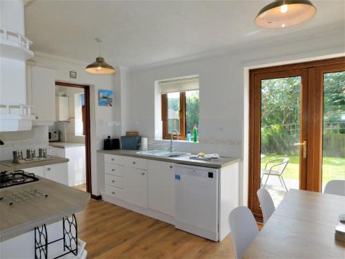 a kitchen with white cabinets and a table with chairs at Railway View in Cromer