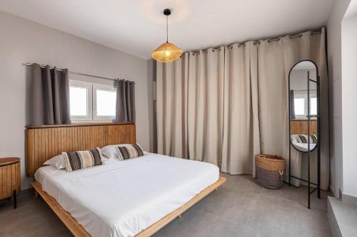 une chambre avec un grand lit blanc et une fenêtre dans l'établissement Maisonnette à 400m de la Plage, à Villeneuve-Loubet