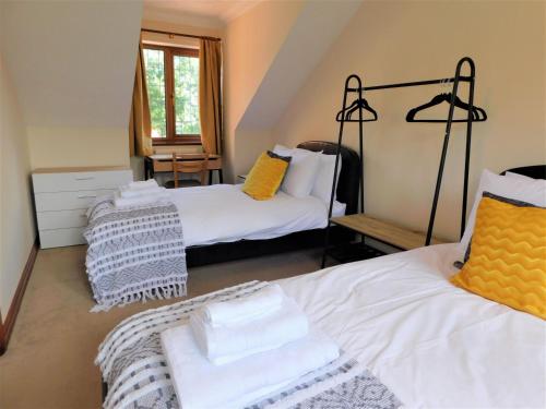 a room with two beds with yellow and white pillows at Railway View in Cromer