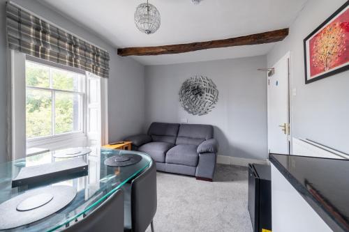 a living room with a couch and a glass table at Crown and Cushion Appleby in Appleby