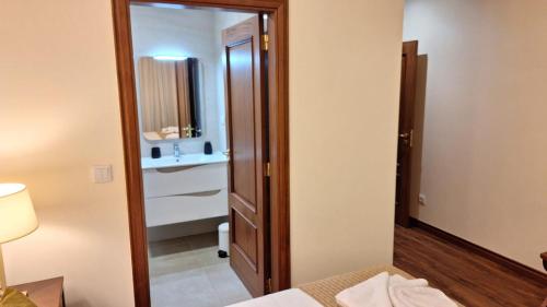 a room with a mirror and a bed and a bathroom at Theo's City House in Funchal