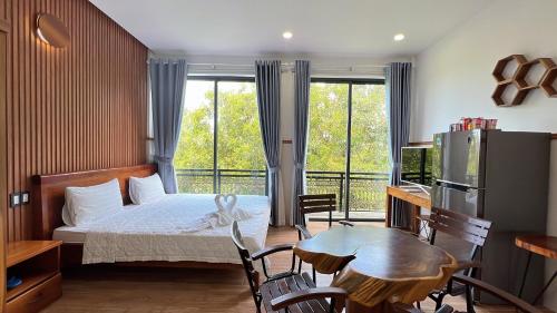 um quarto com uma cama, uma mesa e cadeiras em Nhu Huose Phu Quoc em Phu Quoc