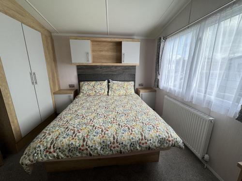 a bedroom with a bed with a floral bedspread at Beautiful 2-Bed Holiday home in Whitstable