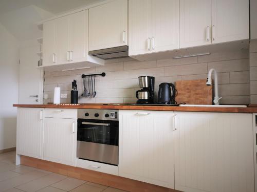a kitchen with white cabinets and a stove top oven at Ferienwohnung Zollstraße 12 EG in Bleckede