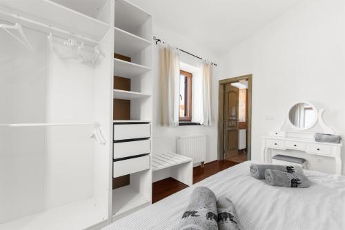 a white bedroom with a bed and a mirror at Vila Majda in Čabrunići