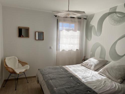 Un dormitorio con una cama y una silla y una ventana. en Appt à Ancelle pied des pistes, en Ancelle
