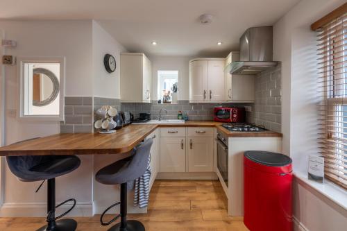 a kitchen with white cabinets and a wooden counter top at Crown and Cushion Appleby in Appleby