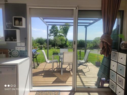 un patio avec une table et des chaises sur une terrasse dans l'établissement Gîte indépendant avec vue sur Mont St Michel, à Lolif