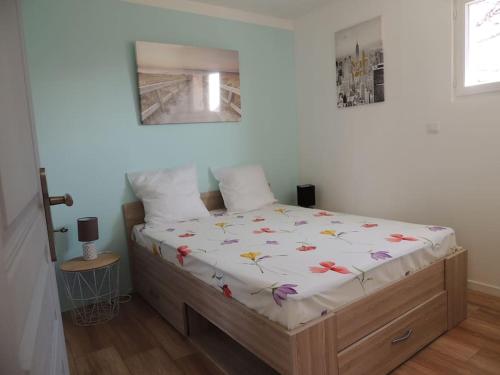 - une chambre avec un lit fleuri dans l'établissement Gîte indépendant avec vue sur Mont St Michel, à Lolif