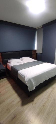 ゲブゼにあるVOLENS HOTELの青い壁のベッドルーム1室(大型ベッド1台付)