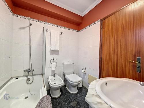 a bathroom with a toilet and a bath tub at Domus Dino in Porto da Cruz