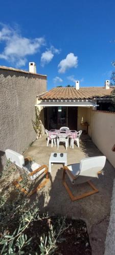 d'une terrasse avec deux chaises et une table. dans l'établissement Agréable petite maison 2 chambres, de 48m2 sans vis-à-vis et parking privatif, au Cap d'Agde