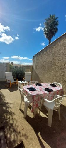 une table et des chaises assises sur une terrasse dans l'établissement Agréable petite maison 2 chambres, de 48m2 sans vis-à-vis et parking privatif, au Cap d'Agde