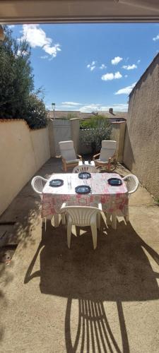 une table et des chaises assises sur une terrasse dans l'établissement Agréable petite maison 2 chambres, de 48m2 sans vis-à-vis et parking privatif, au Cap d'Agde