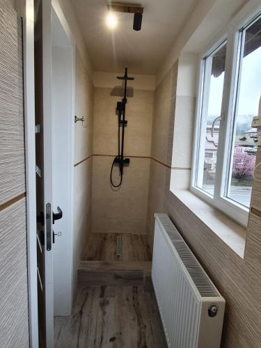 a bathroom with a shower with a cross on the wall at Villa Coca in Câmpulung Moldovenesc