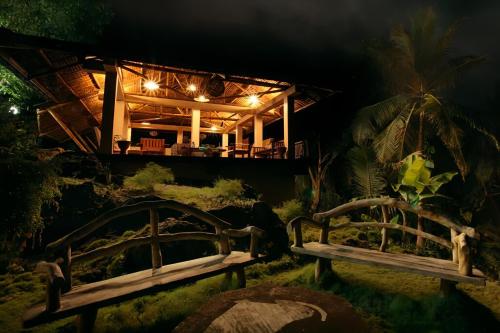 two benches in front of a house at night at Siargao Million Dollar View in Burgos