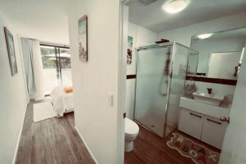 a bathroom with a shower and a toilet and a sink at Beach Pad Private Town house Sea Views Dual living 5 Beds in Redcliffe