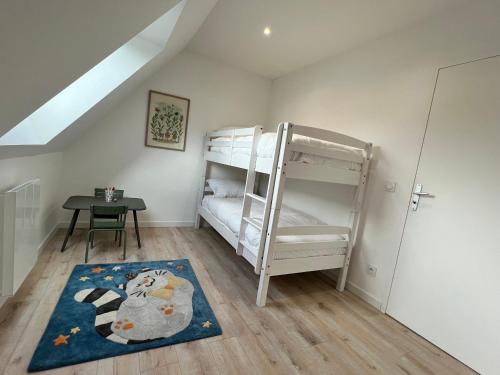 Cette petite chambre comprend des lits superposés et un tapis. dans l'établissement La maison sur la Ria _ 8 voyageurs, à Plouhinec