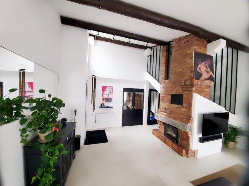 En un edificio hay una sala de estar con chimenea de ladrillo. en The Cosy House, en Périgny