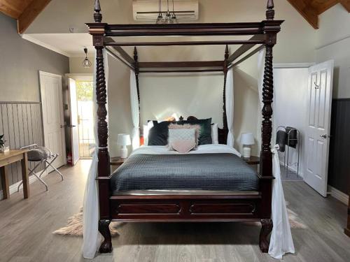 a bedroom with a canopy bed in a room at Kookaburra Cottage Gembrook in Gembrook