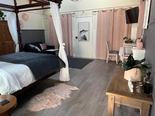 a bedroom with a canopy bed and a rug at Kookaburra Cottage Gembrook in Gembrook