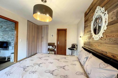 1 dormitorio con 1 cama grande y pared de madera en Bristol Comfort & Nature in the Heart of the Alps!, en Lens