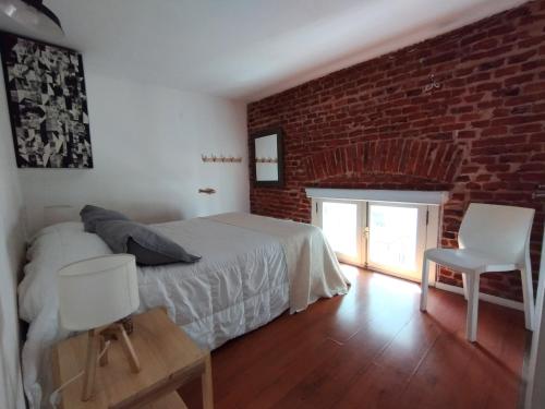 a bedroom with a bed and a brick wall at Zabalita, hermoso y cálido loft en la Ciudad Vieja in Montevideo