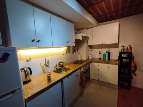 a kitchen with white cabinets and a sink at Zabalita, hermoso y cálido loft en la Ciudad Vieja in Montevideo