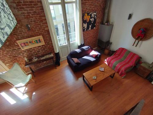 a living room with a couch and a table at Zabalita, hermoso y cálido loft en la Ciudad Vieja in Montevideo