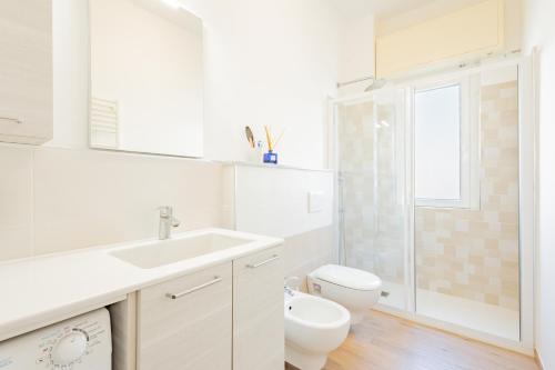 a white bathroom with a toilet and a sink at Appartamento vista mare di Marco in Spotorno