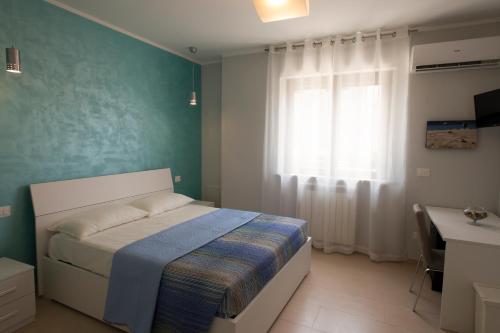 um quarto com uma cama, uma janela e uma secretária em B&B Olganna em Vasto
