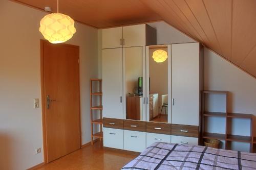 een slaapkamer met een grote witte kast met een spiegel bij Ferienwohnung Preisinger in Gammertingen