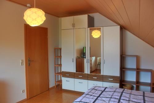 a bedroom with a large white cabinet with a mirror at Ferienwohnung Preisinger in Gammertingen