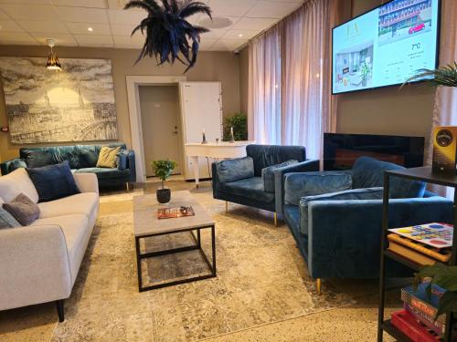 a living room with couches and a flat screen tv at Lidingö Arena Hotel in Lidingö