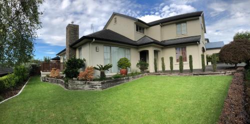a house with a large lawn in front of it at Tauranga Homestead Retreat in Tauranga