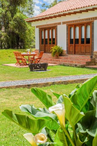 a house with a table and chairs in the yard at Casa de las Flores- Chalet Privado in Villa de Leyva