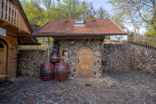 a stone building with barrels and a wooden door at Rudnica Hill Lodge - Happy Rentals in Podčetrtek