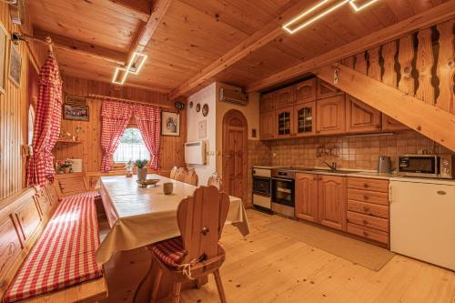 a kitchen with wooden cabinets and a table in a room at Rudnica Hill Lodge - Happy Rentals in Podčetrtek