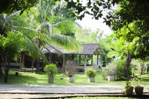 un jardín con un pabellón con palmeras y plantas en Grand Okka Hotel en Buttala
