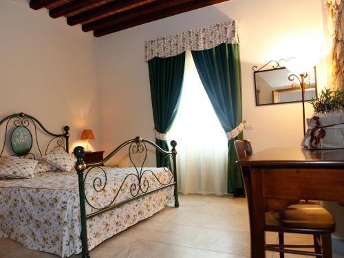 a bedroom with a bed and a desk and a window at Villa Alba in Marciana Marina